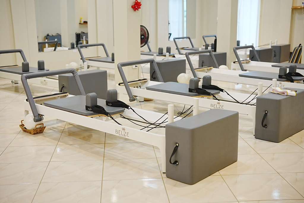 Reformers lined up inside the Belize Pilates studio